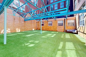a green lawn in front of a brick building